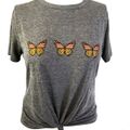 This is the butterfly t-shirt that Sheila wore along with a pair of light wash jeans during planning for Sal's party; She also had her saddle bag with her. 239802.