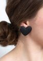 The large matte black heart shaped earrings that Haukea wore during a medical appointment in which she asked Doctor Madison Marsh out on a date.